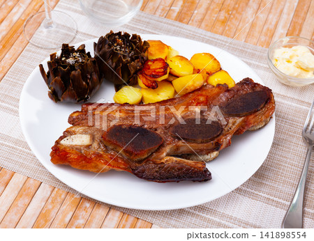 Popular spanish dish is beef churasco with potatoes and artichokes Popular spanish dish is beef churasco with potatoes and artichokes 141898554