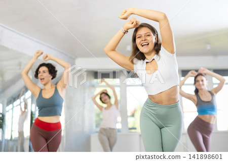 Young female teacher conducts modern hip hop dance lessons for group of girls Young female teacher conducts modern hip hop dance lessons for group of girls 141898601