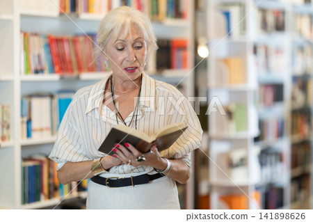 Elderly woman choosing book in bookstore 141898626