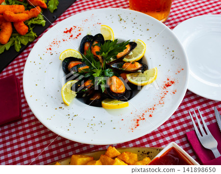 Steamed mussel served with lemon Steamed mussel served with lemon 141898650