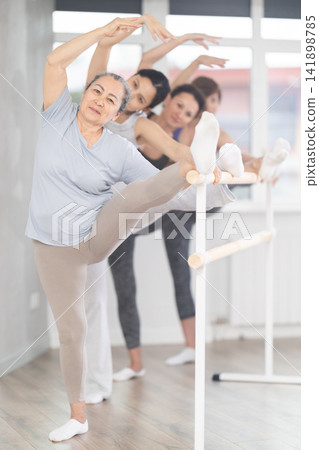Group of women stretching at ballet barre Group of women stretching at ballet barre 141898785