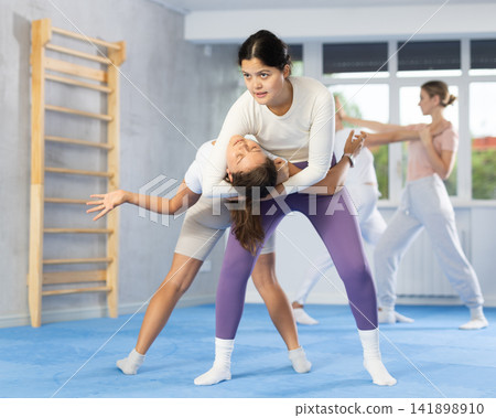 Asian woman practicing reverse headlock in sparring during self-defence training Asian woman practicing reverse headlock in sparring during self-defence training 141898910