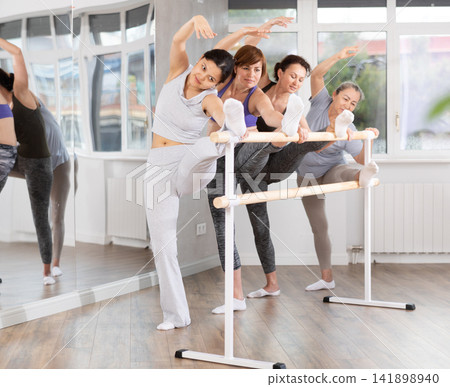 Group of women stretching at ballet barre Group of women stretching at ballet barre 141898940