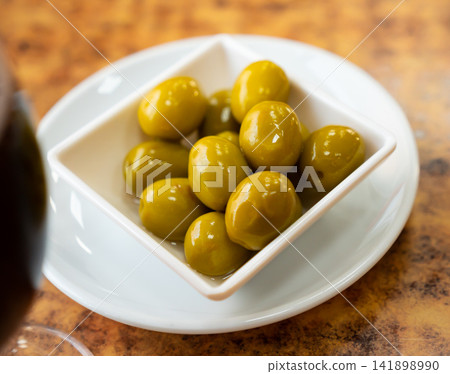 Bowl of green olives on wooden table Bowl of green olives on wooden table 141898990