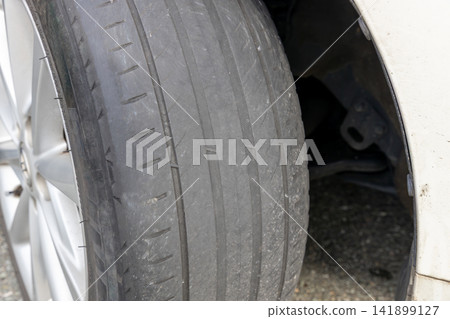 Tires that are worn down to the point where the wear indicators are almost touching. Tires that are worn down to the point where the wear indicators are almost touching. 141899127