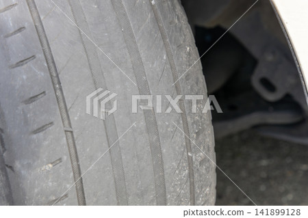 Tires that are worn down to the point where the wear indicators are almost touching. Tires that are worn down to the point where the wear indicators are almost touching. 141899128