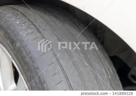 Tires that are worn down to the point where the wear indicators are almost touching. Tires that are worn down to the point where the wear indicators are almost touching. 141899129
