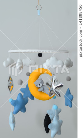Cute teddy bear sleeping on crescent moon baby crib mobile with clouds and stars Cute teddy bear sleeping on crescent moon baby crib mobile with clouds and stars 141899450