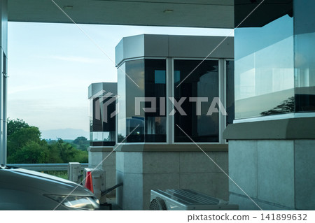 Modern highway entrance toll booths with glass-enclosed payment stations Modern highway entrance toll booths with glass-enclosed payment stations 141899632