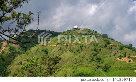 Buddhist temple on a green hill in Nuwara Eliya, Sri Lanka, under dramatic cloudy skies Buddhist temple on a green hill in Nuwara Eliya, Sri Lanka, under dramatic cloudy skies 141899715