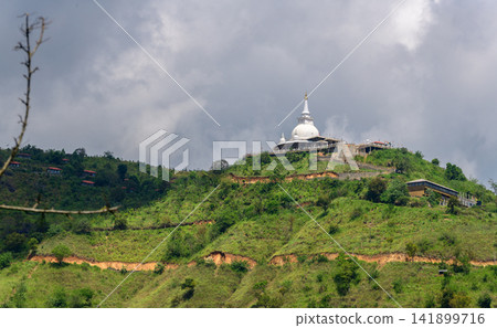 Buddhist temple on a green hill in Nuwara Eliya, Sri Lanka, under dramatic cloudy skies Buddhist temple on a green hill in Nuwara Eliya, Sri Lanka, under dramatic cloudy skies 141899716