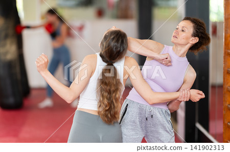 Woman trying elbow strike in sparring Woman trying elbow strike in sparring 141902313