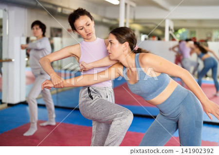 Women in pair perform effective impact on pain points while learning self-defense. Women in pair perform effective impact on pain points while learning self-defense. 141902392