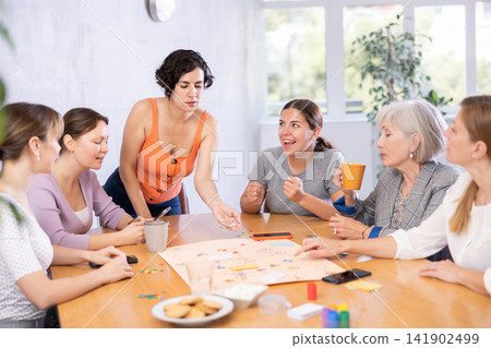 Young female moderator throws stones and determines order of parties in board game 141902499