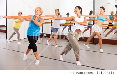 Women performing contemporary dance in training room Women performing contemporary dance in training room 141902514