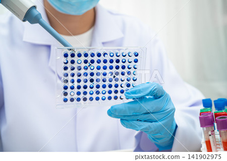 Scientist with cell culture in sample micro plate for research in science laboratory. Scientist with cell culture in sample micro plate for research in science laboratory. 141902975