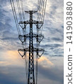 I look up at the high-voltage transmission towers and the clouds that are spreading and moving along with them. 141903880