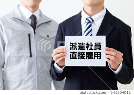 一位身穿西裝的年輕商人手持白板,向臨時工提供直接就業機會。 一位身穿西裝的年輕商人手持白板,向臨時工提供直接就業機會。 141904011