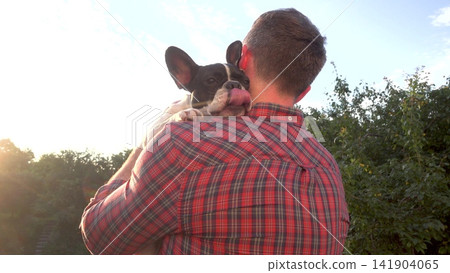 Cute French Bulldog resting head on male owner's shoulder Cute French Bulldog resting head on male owner's shoulder 141904065