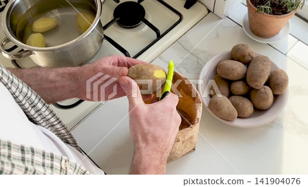 Man peels a potato Man peels a potato 141904076