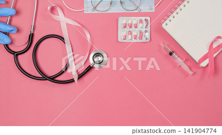Breast cancer awareness and treatment concept with pink ribbon stethoscope pills syringe and blank notebook 141904774