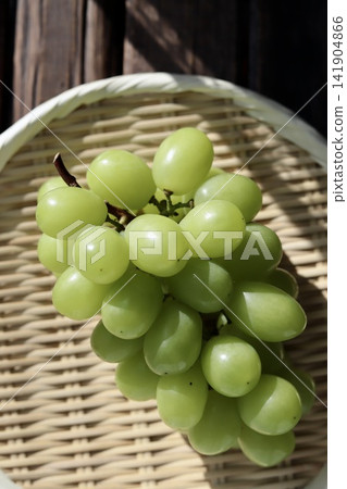 美味但略帶瑕疵的 Shine Muscat 葡萄盛放在竹篩上。 美味但略帶瑕疵的 Shine Muscat 葡萄盛放在竹篩上。 141904866