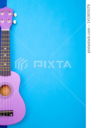 Four string ukulele guitar on blue background Four string ukulele guitar on blue background 141905076