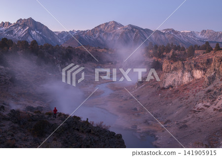 Majestic mountain landscape view shows steam rising near sierra nevada peaks as lone hiker feels peaceful awe during quiet chilly sunrise Majestic mountain landscape view shows steam rising near sierra nevada peaks as lone hiker feels peaceful awe during quiet chilly sunrise 141905915