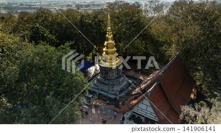 golden pagoda of Wat Phra That Chom Kitti in Chiang Rai. The ancient Buddhist stupa is surrounded by lush green trees on 13 January 2023. golden pagoda of Wat Phra That Chom Kitti in Chiang Rai. The ancient Buddhist stupa is surrounded by lush green trees on 13 January 2023. 141906141