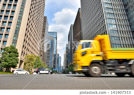 A yellow truck is driving through an intersection. A yellow truck is driving through an intersection. 141907553
