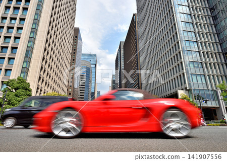 十字路口停著一輛紅色汽車。 十字路口停著一輛紅色汽車。 141907556