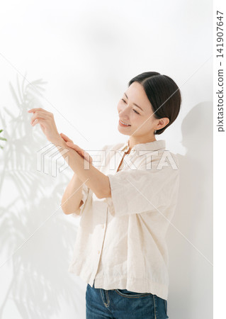 一位三十多歲的女性正在保養她的手臂。 一位三十多歲的女性正在保養她的手臂。 141907647