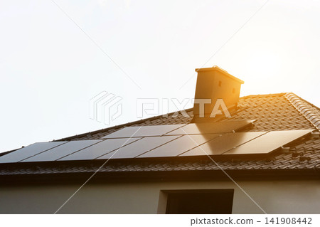 Solar power energy on the roof to a standard house. Solar power panels ,Photovoltaic modules for innovation green energy for life with blue sky background. High quality photo 141908442
