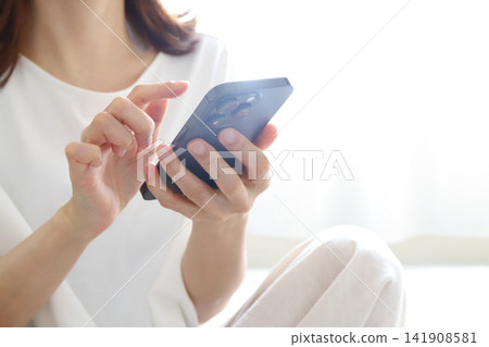 操作智能手機的婦女 操作智能手機的婦女 141908581