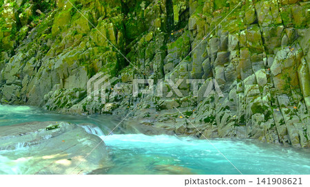一條清澈美麗的溪流在嶙峋的岩石峭壁間潺潺流淌。 一條清澈美麗的溪流在嶙峋的岩石峭壁間潺潺流淌。 141908621
