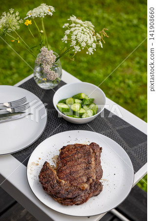 Freshly Grilled Beef Steak on Plate on Garden Terrace Table Freshly Grilled Beef Steak on Plate on Garden Terrace Table 141908660