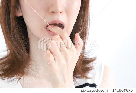 A woman experiencing tooth pain due to tooth sensitivity. 141908679