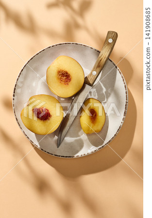 Fresh Juicy Sliced Peach on Pastel Background with Sunlight, Top View Fresh Juicy Sliced Peach on Pastel Background with Sunlight, Top View 141908685