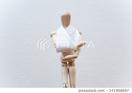 一個手臂上纏著三角形繃帶的繪圖人體模型。 一個手臂上纏著三角形繃帶的繪圖人體模型。 141908697