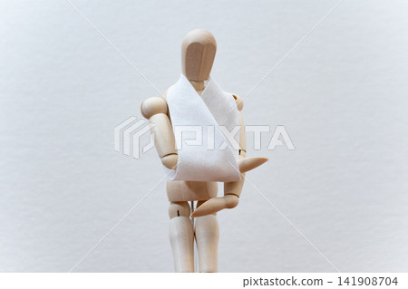 A drawing mannequin with a triangular bandage on its arm. A drawing mannequin with a triangular bandage on its arm. 141908704