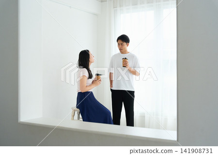 一對年輕男女在輕鬆的房間裡交談。 一對年輕男女在輕鬆的房間裡交談。 141908731