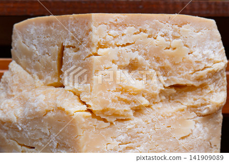 Hard cheese as wheel and piece on grocery shop shelf 141909089
