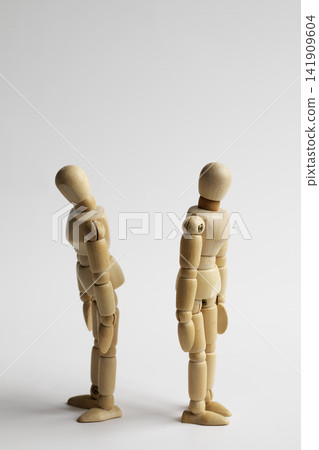 Two wooden figures with their backs to each other Two wooden figures with their backs to each other 141909604
