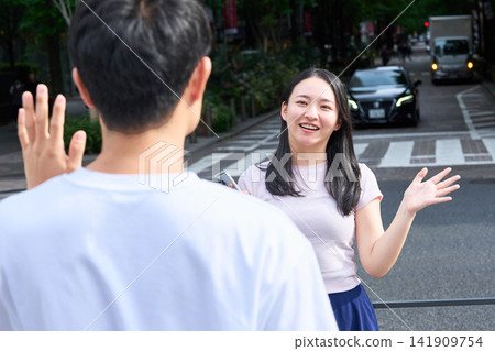 A young man and woman meeting on a street corner A young man and woman meeting on a street corner 141909754