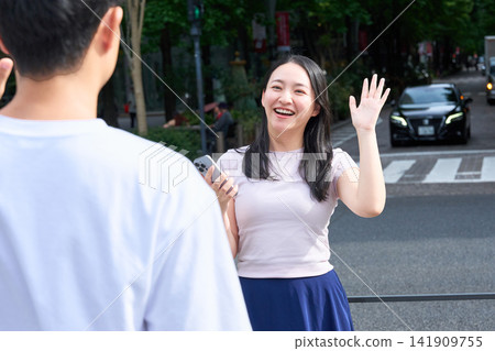 A young man and woman meeting on a street corner A young man and woman meeting on a street corner 141909755