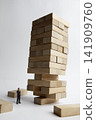 Precarious wooden blocks and miniature businessman 141909760