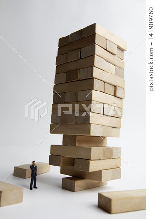 Precarious wooden blocks and miniature businessman Precarious wooden blocks and miniature businessman 141909760