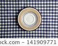 A plate on a blue and white checkered tablecloth 141909771