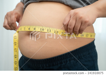 Asian woman with fat belly big size overweight and obesity with measure tape. Asian woman with fat belly big size overweight and obesity with measure tape. 141910075