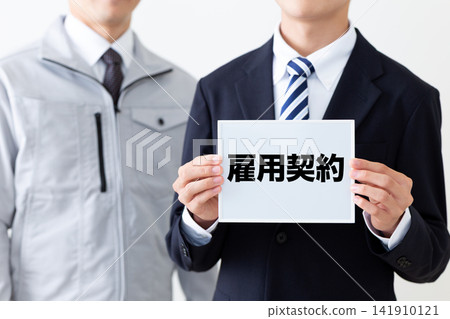 身穿西裝的年輕商人,手持一塊寫滿聘約的白板。 身穿西裝的年輕商人,手持一塊寫滿聘約的白板。 141910121